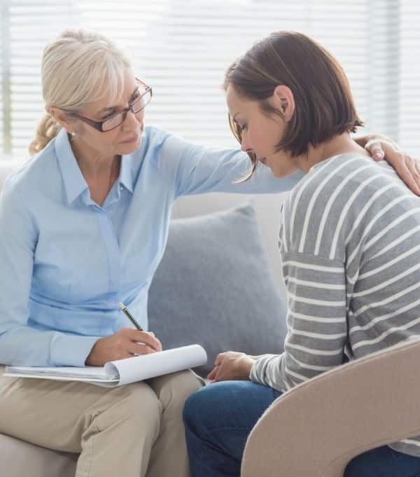 Woman conducting a 1:1 wellness coaching session in person